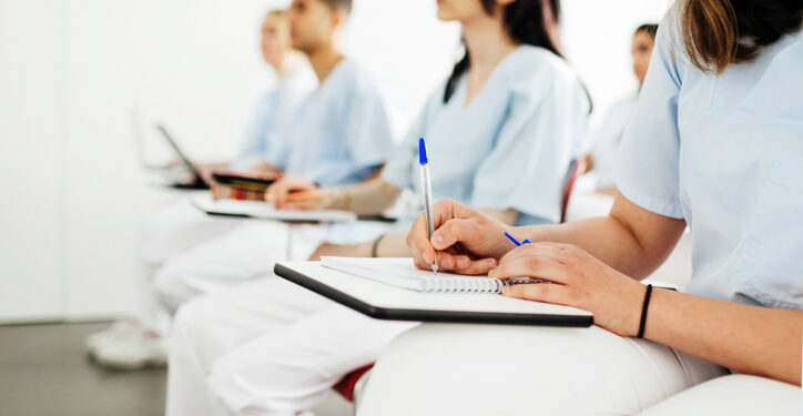 A group of nurses taking notes during a lecture at university.